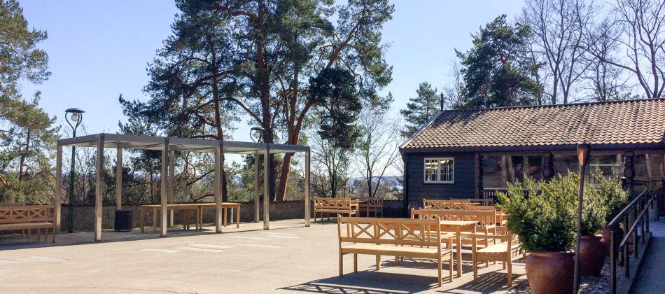 Gårdsplassen på Gjestestuene med hagemøbler og utsikt over Folkemuseet på Bygdøy